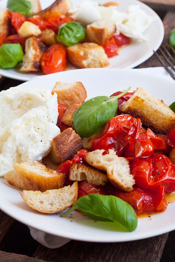 Der sommerliche Brotsalat mit gerösteten Tomaten und Mozzarella ist die perfekte Mischung aus knusprig, würzig und cremig. Schnell, einfach und unglaublich gut - kochkarussell.com