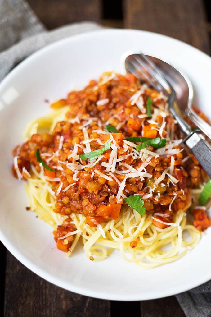 Vegane 20-Minuten Rote Linsen-Bolognese mit Parmesan und Petersilie auf einem weißen Teller