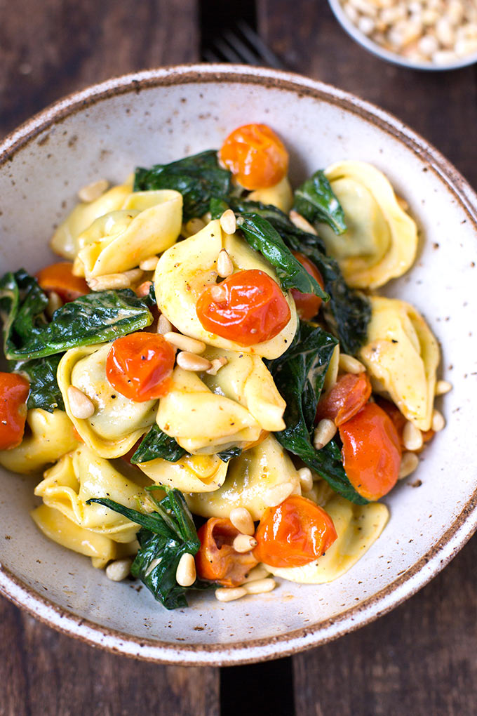 Tortellini mit Tomaten-Sahnesauce und Spinat. Dieses 8-Zutaten Rezept ist einfach, in 20 Minuten fertig und SO gut - Kochkarussell.com