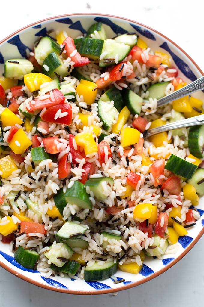 Vegetarischer Reissalat in einer Schüssel auf einem hellen, weißen Untergrund.