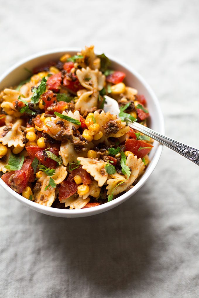 Werbung. Einfacher Taco Nudelsalat mit würzigem Hackfleisch, Tomaten, Nudeln, Mais, Koriander und Taco Sauce. Super schnell gemacht und SO gut - Kochkarussell.com