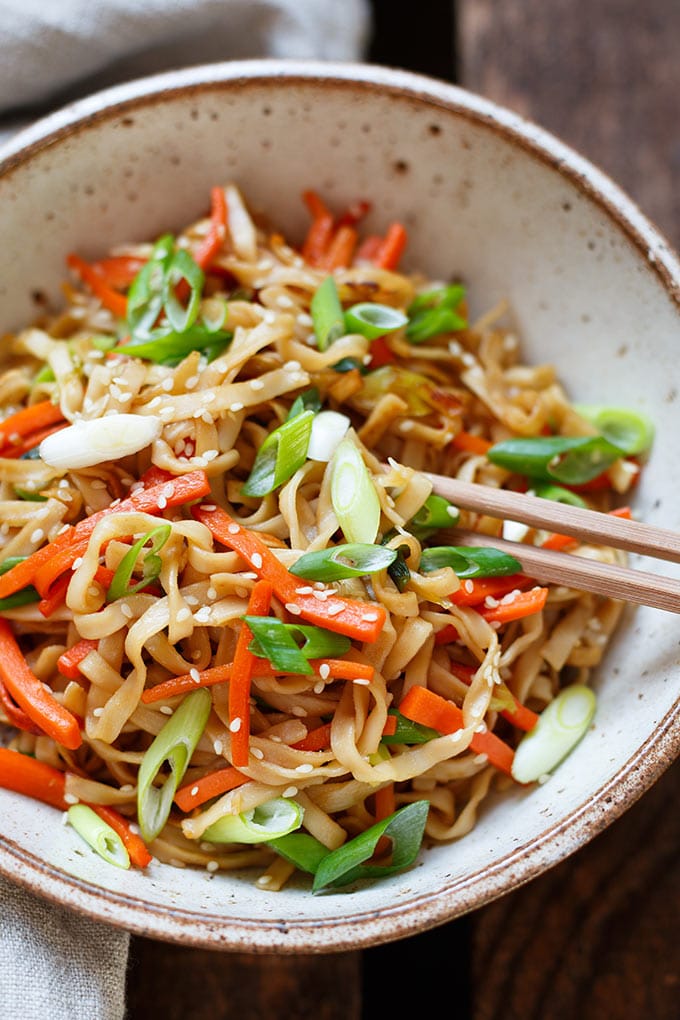 Gebratene Asia Noodles in einer Schüssel mit Stäbchen und Sesam