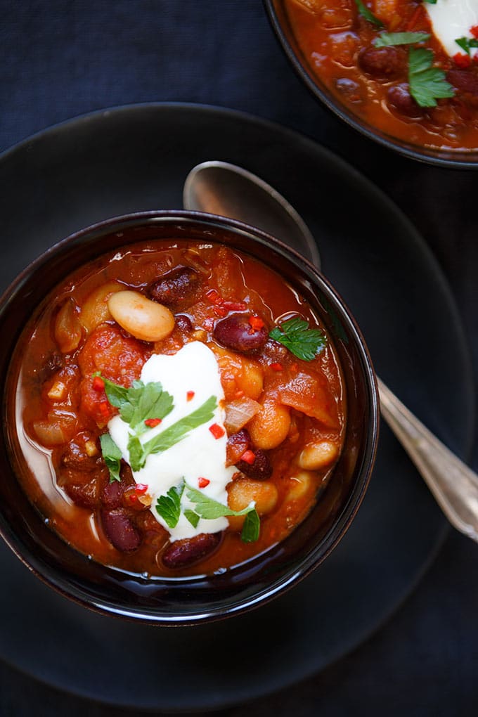 Magisches Chili sin Carne mit Kidneybohnen, weißen Bohnen und gehackten Tomaten. Dieses 20-Minuten Rezept ist vegetarisch, super schnell vorbereitet und absolutes Soulfood. Perfekt für den Feierabend! - Kochkarussell.com #chili #chilisincarne #dinner #soulfood #stew #healthy #vegetarian