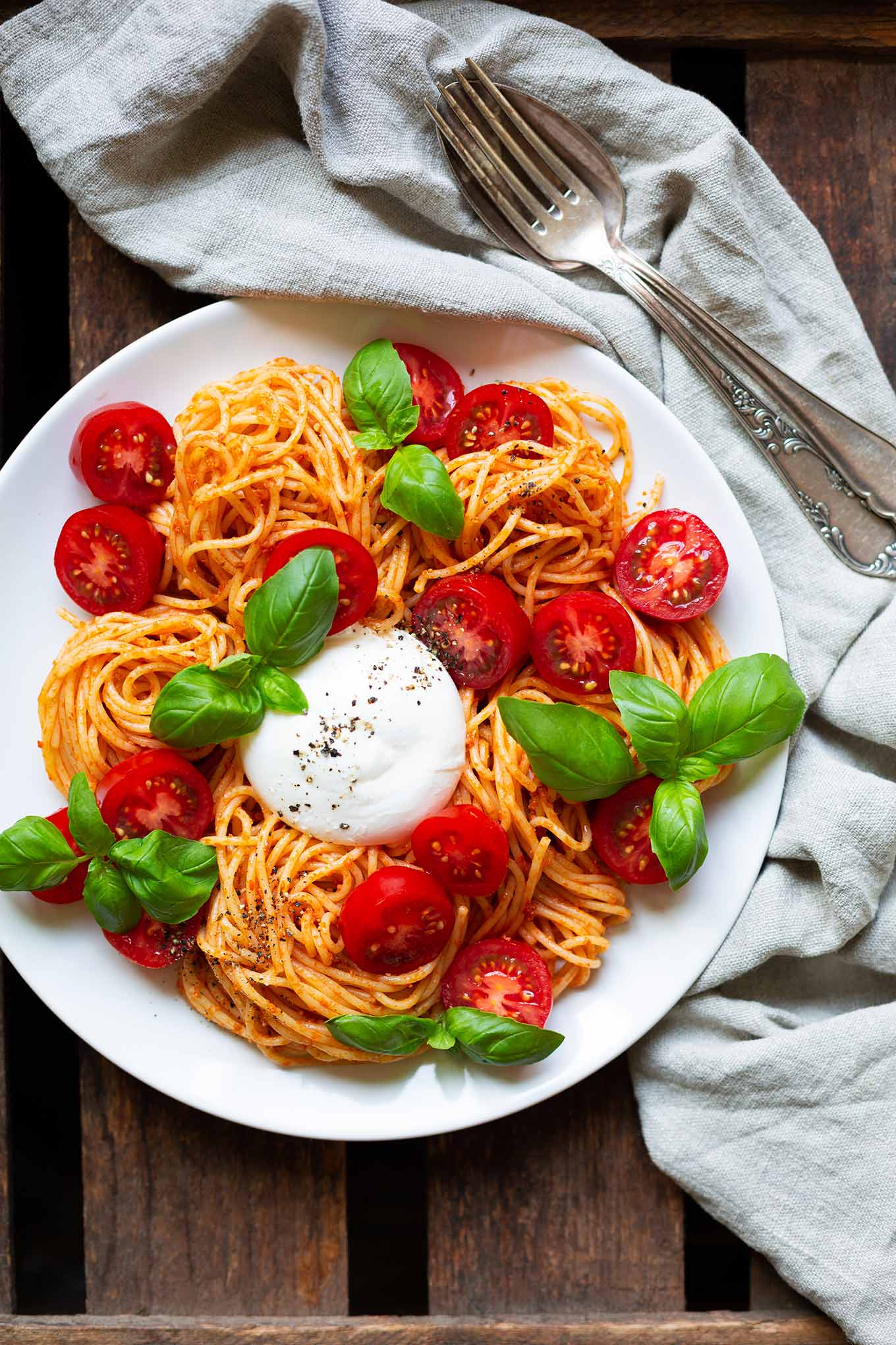 Tomaten-Pesto-Spaghetti mit Burrata und Basilikum. Dieses 5-Zutaten Rezept ist einfach, schnell und perfekt für heiße Sommertage. So gut! - Kochkarussell.com #spaghetti #burrata #sommerrezept #tomaten #schnellundeinfach