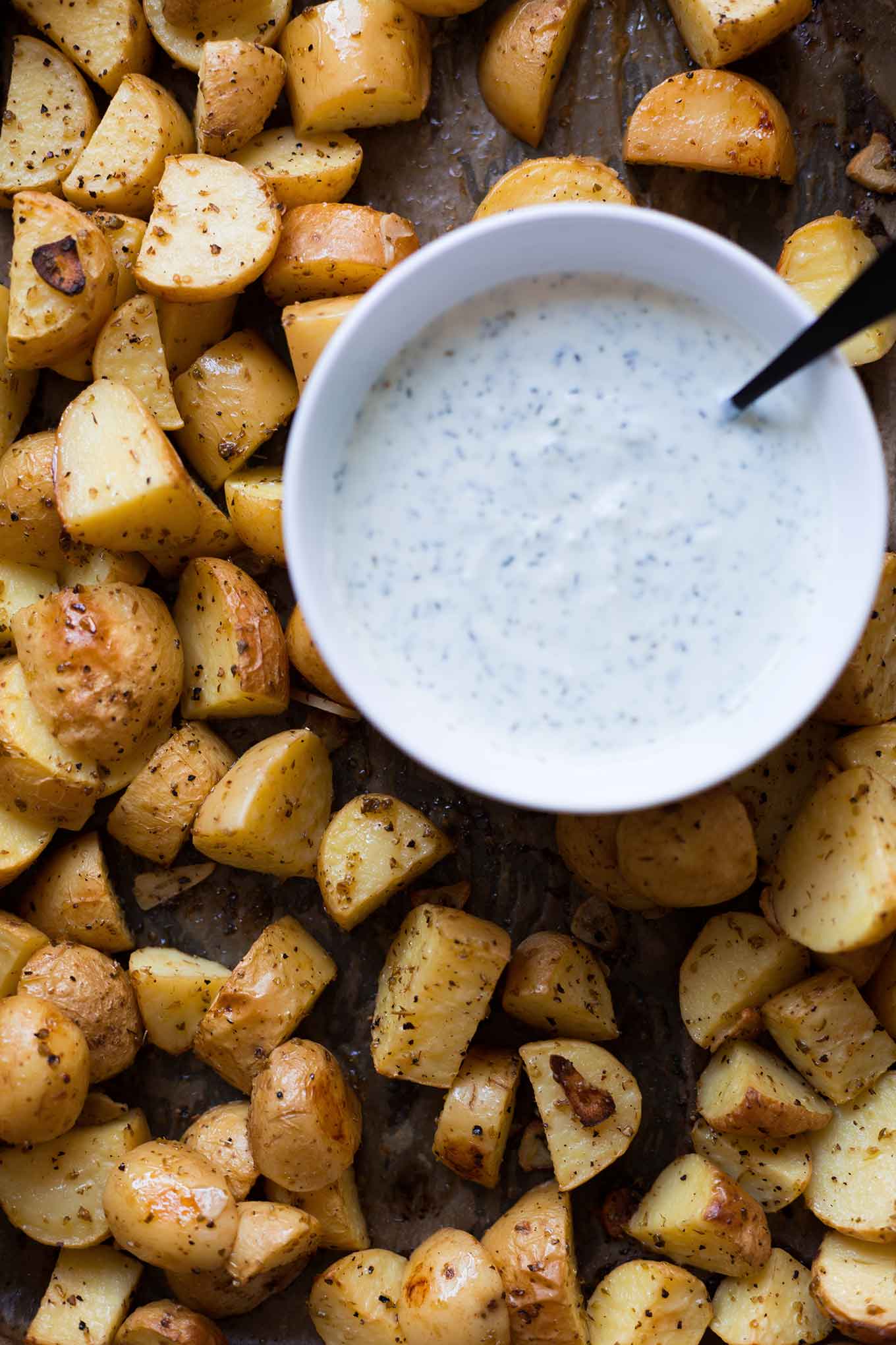 Griechische Ofenkartoffeln mit Joghurt-Feta-Dip. Dieses schnelle Rezept ist super einfach, leicht und SO gut! - Kochkarussell.com #ofenkartoffeln #rezept #sommerrezept #schnellundeinfach #zitrone #dip 