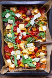 Ein Blech-Ravioli mit Tomaten, Paprika und Rucola