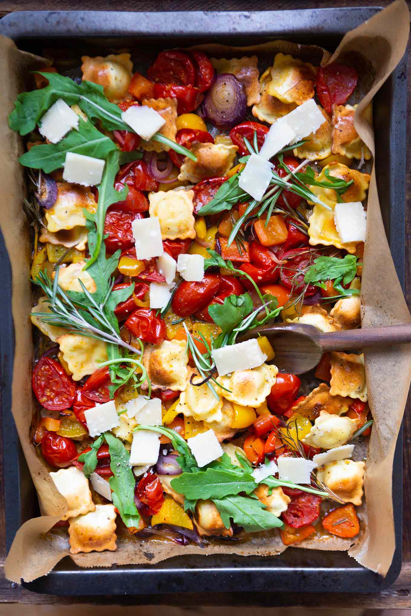 Ein Blech-Ravioli mit Tomaten, Paprika und Rucola. Dieses schnelle und einfache Rezept ist der Renner an keine Lust zu kochen Tagen, unbedingt probieren! - Kochkarussell.com #einblechrezept #schnellundeinfach #feierabendküche #kochkarussell