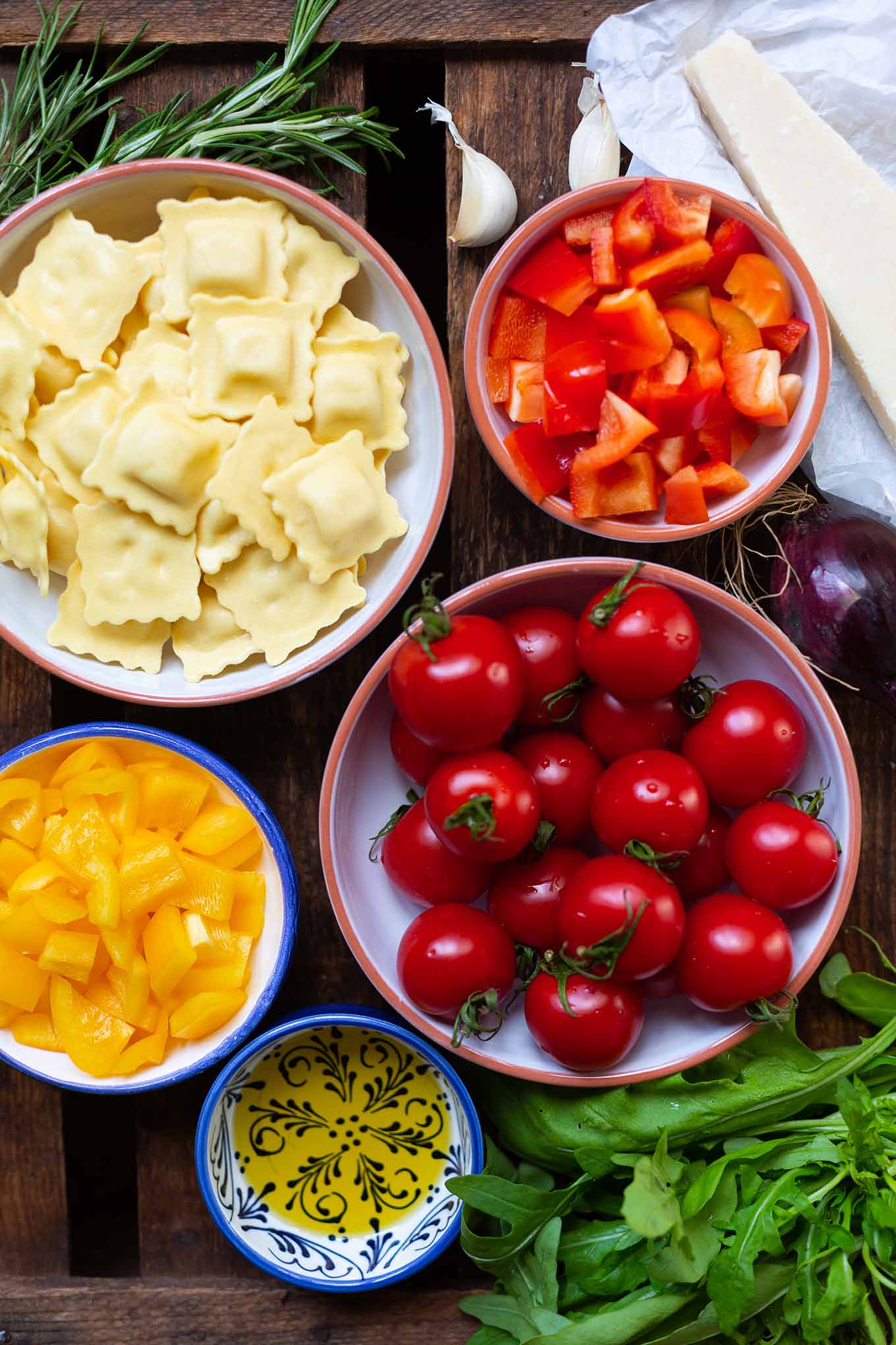 Ein Blech-Ravioli mit Tomaten, Paprika und Rucola. Dieses schnelle und einfache Rezept ist der Renner an keine Lust zu kochen Tagen, unbedingt probieren! - Kochkarussell.com #einblechrezept #schnellundeinfach #feierabendküche #kochkarussell