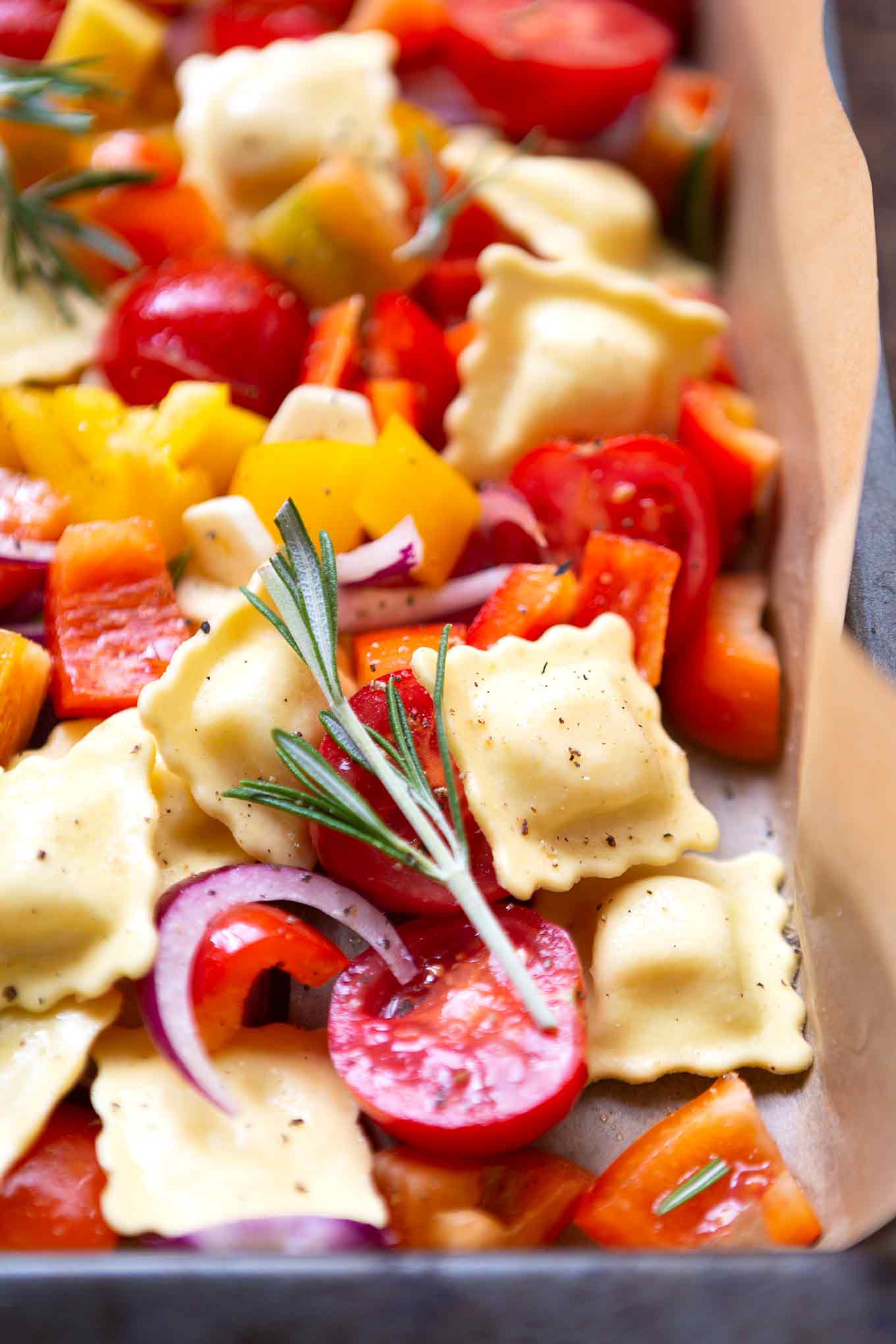 Ein Blech-Ravioli mit Tomaten, Paprika und Rucola. Dieses schnelle und einfache Rezept ist der Renner an keine Lust zu kochen Tagen, unbedingt probieren! - Kochkarussell.com #einblechrezept #schnellundeinfach #feierabendküche #kochkarussell