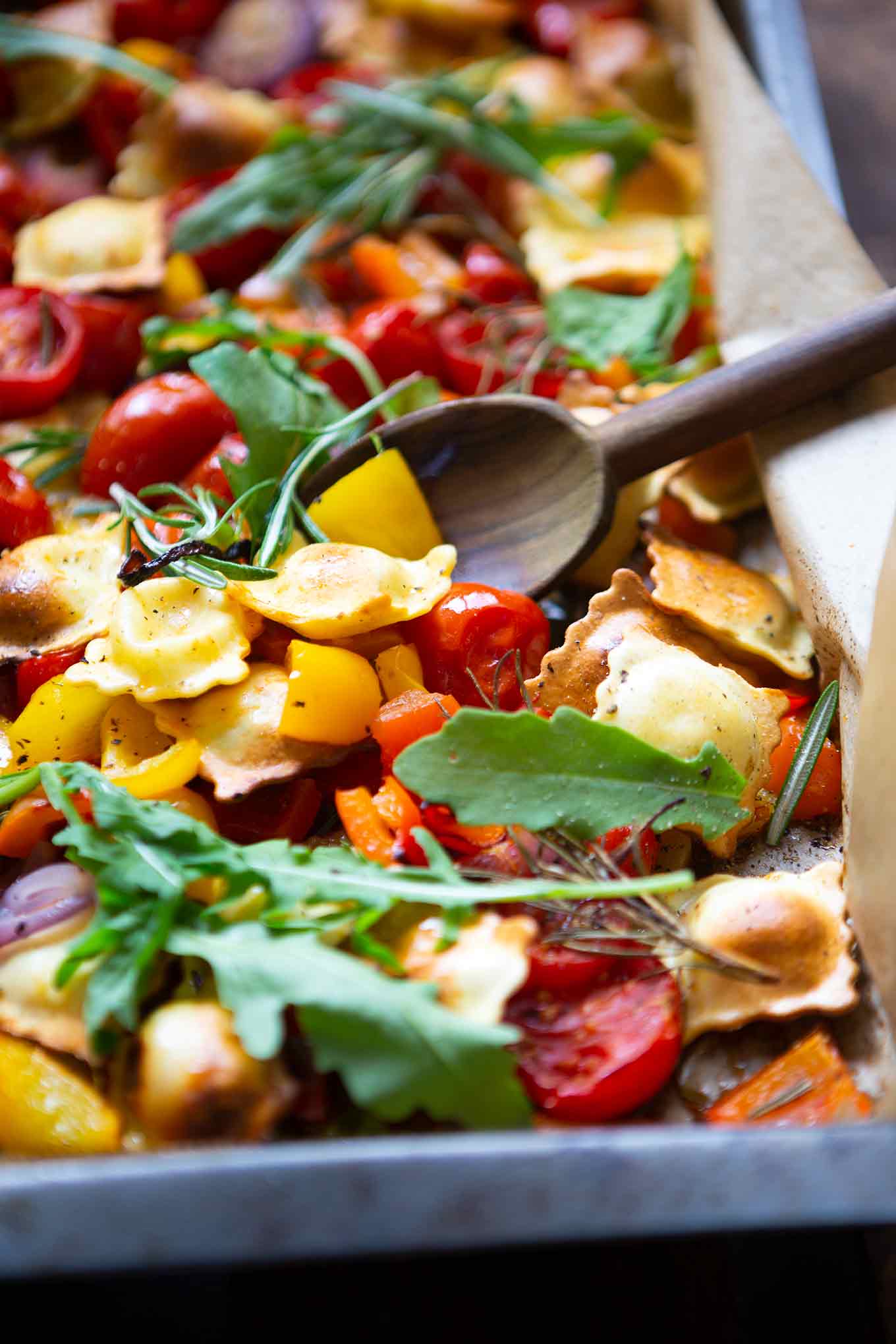 Ein Blech-Ravioli mit Tomaten, Paprika und Rucola. Dieses schnelle und einfache Rezept ist der Renner an keine Lust zu kochen Tagen, unbedingt probieren! - Kochkarussell.com #einblechrezept #schnellundeinfach #feierabendküche #kochkarussell