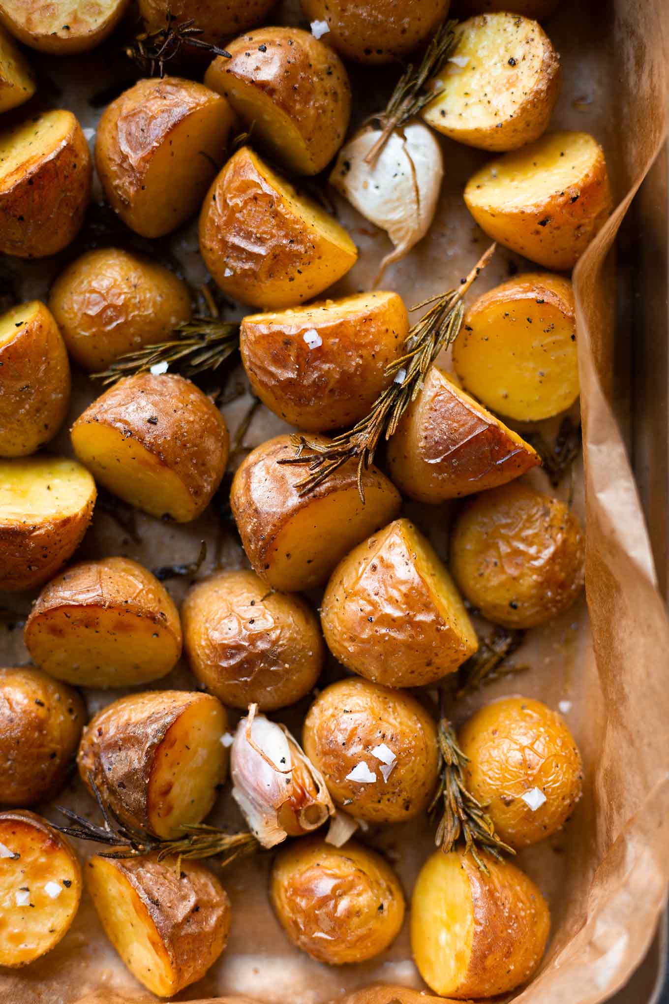 Ein Blech voll einfacher Rosmarinkartoffeln aus dem Ofen mit Knoblauch und Meersalzflocken.