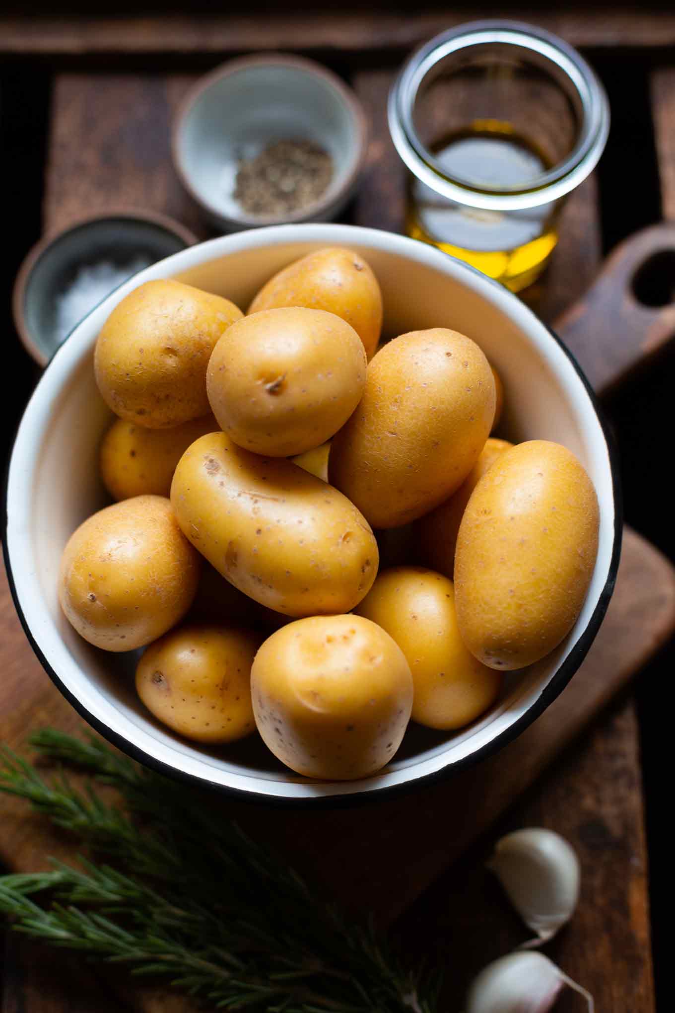 Zutaten für super knusprige und schnelle Rosmarinkartoffeln: Kartoffeln, Öl, Knoblauch, Rosmarin, Salz und Pfeffer.