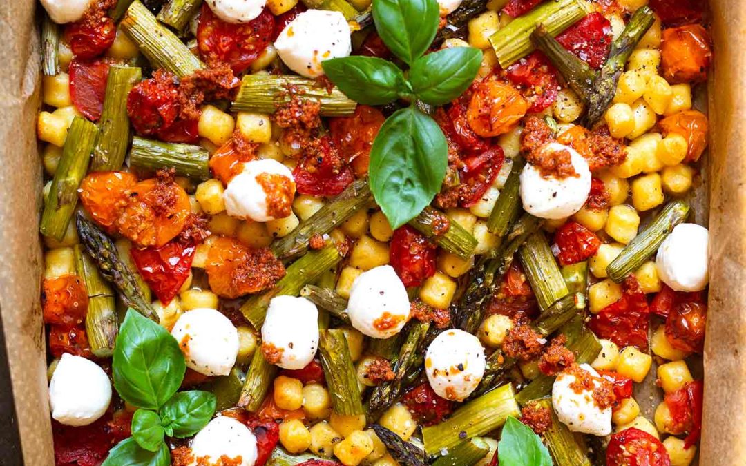 Ein Blech-Gnocchi mit grünem Spargel, Tomaten und Mozzarella