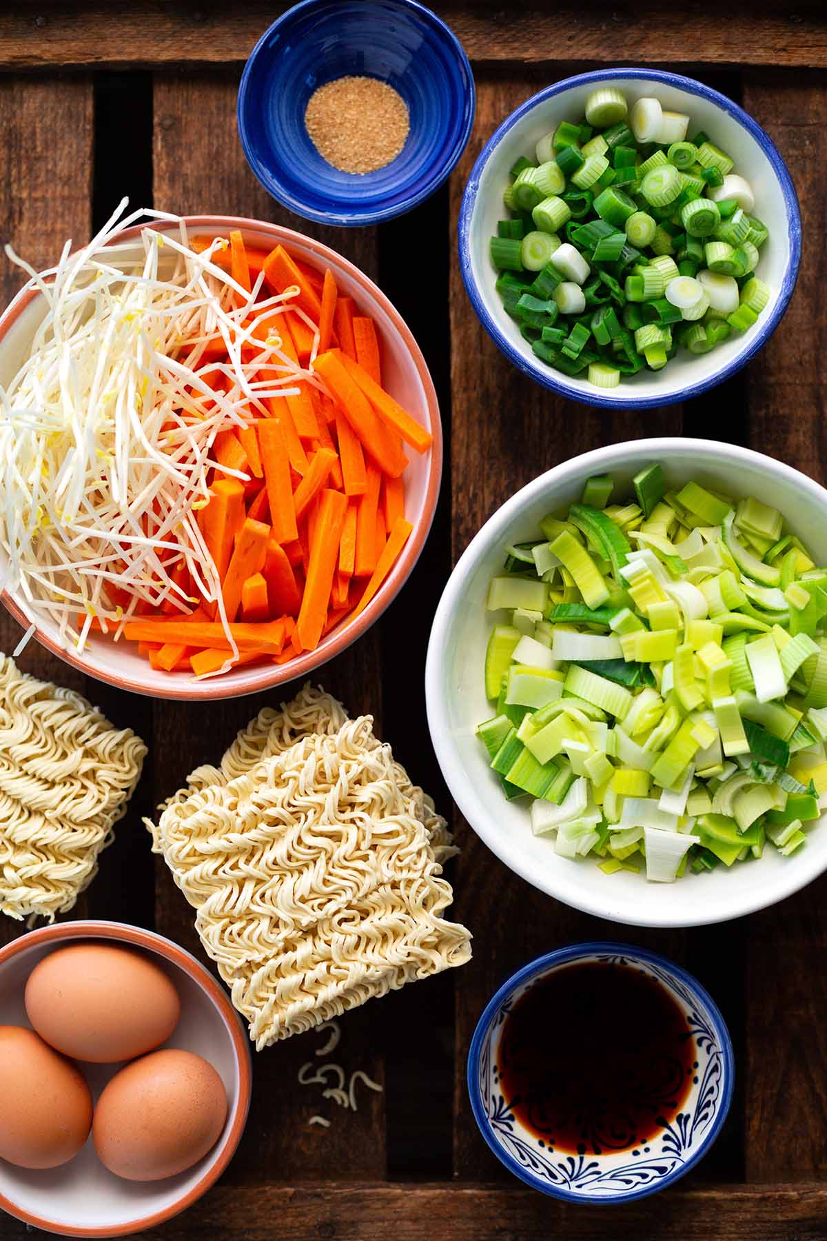 Alle Zutaten für chinesisch gebratene Nudeln mit Gemüse und Ei  wie vom Lieferdienst im Überblick. Mit Lauch,Karotten, Mie Nudeln, Frühlingszwiebeln und Ei.