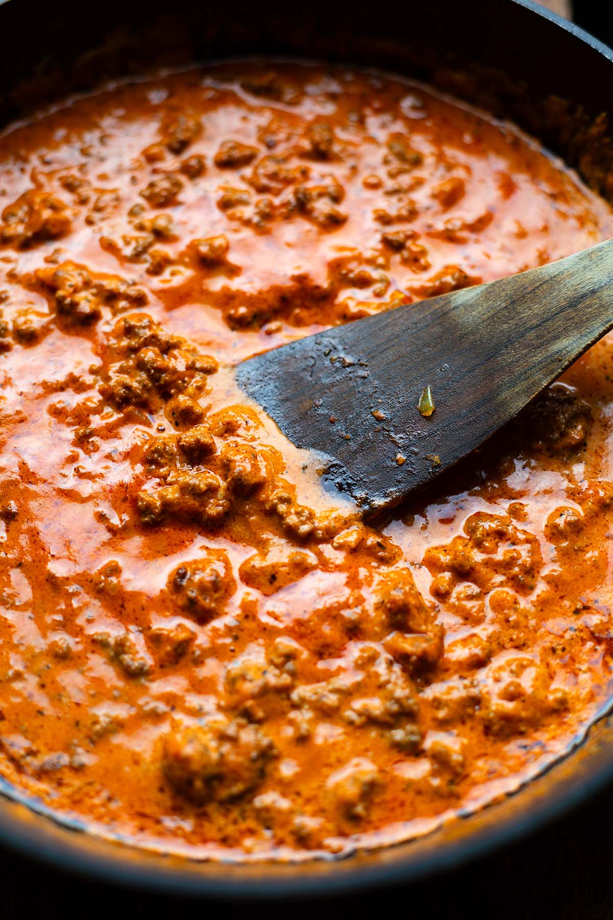 Tomaten-Hack-Soße für den Rigatoni al Forno Auflauf in einer Pfanne beim Einkochen.