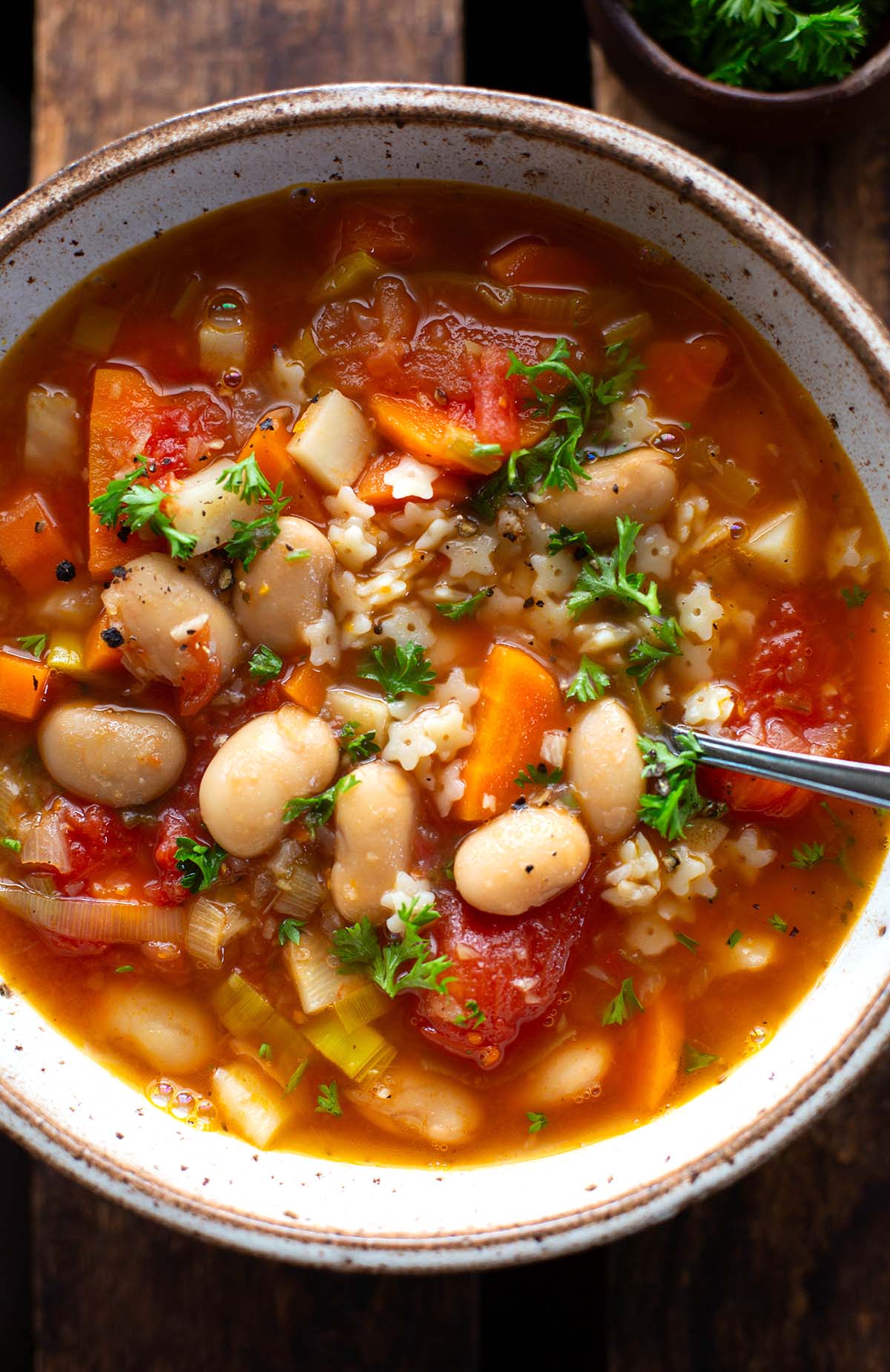 Fertige weiße Bohnensuppe in einer Schüssel, garniert mit Petersilie.