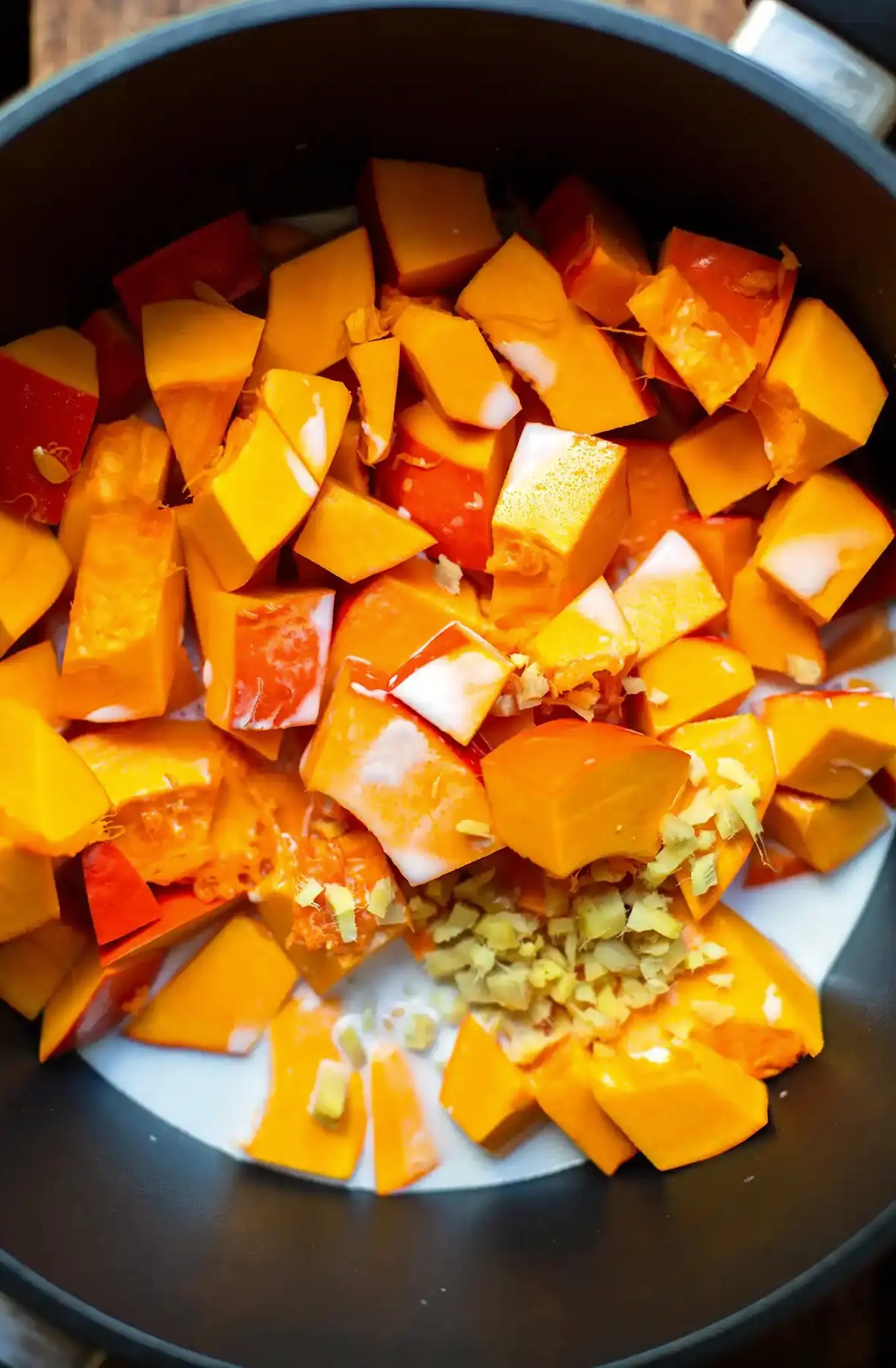 Kürbis, Ingwer, Kokosmilch und Gemüsebrühe im Topf vor dem Kochen