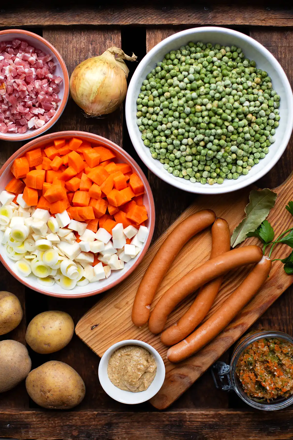 Zutaten für die beste einfache Erbsensuppe auf einem dunklen Holzuntergrund