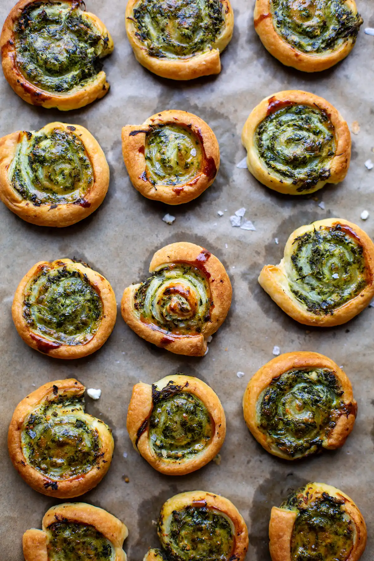 Knusprige Blätterteigschnecken vegetarisch mit Spinat und Feta auf einem Backblech