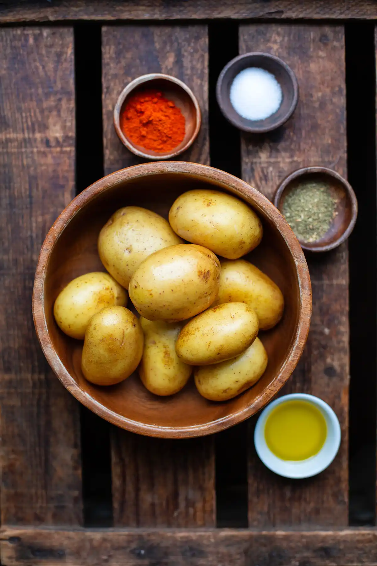 Zutaten für die Potato Wedges: gewaschene, festkochenende Kartoffeln mit Schale, Olivenöl und Paprikapulver, Kräuter und Olivenöl