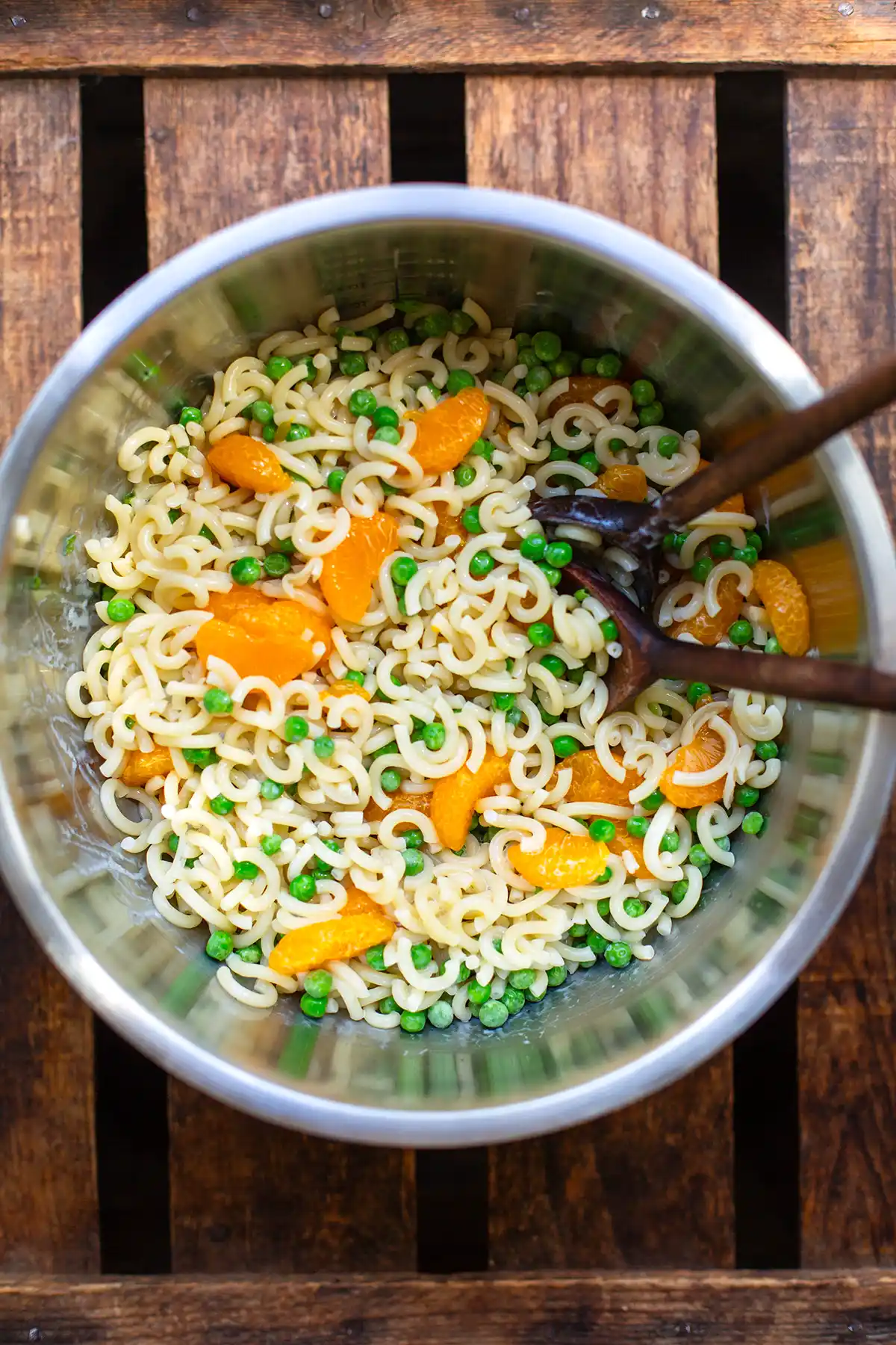 Frisch vermengter Nudelsalat mit Mandarinen und Erbsen in einer großen Schüssel