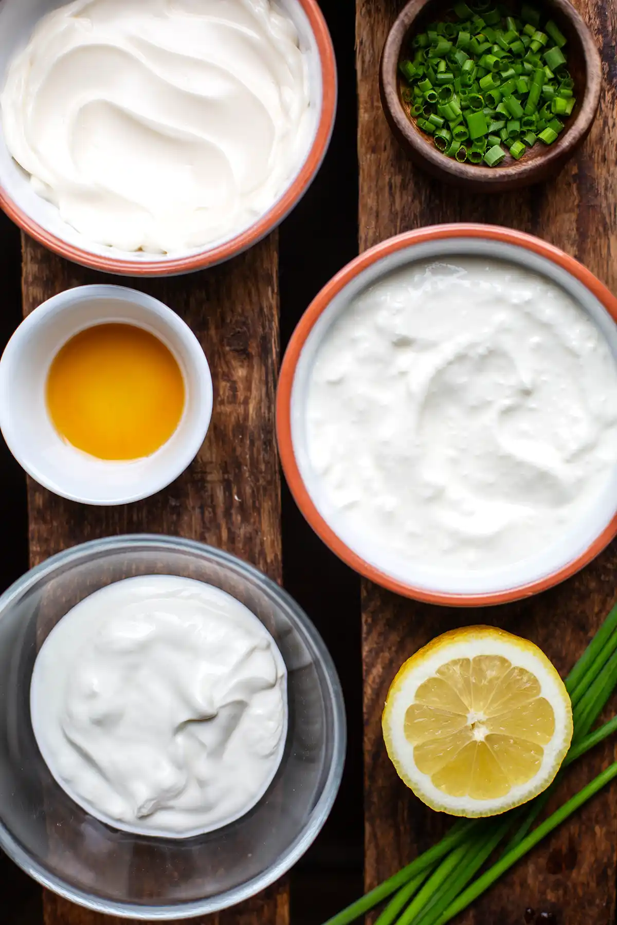 Die Zutaten für den Ofenkartoffel-Dip: Saure Sahne, Skyr, Mayonnaise, frischer Schnittlauch, Ahornsirup und eine Zitrone