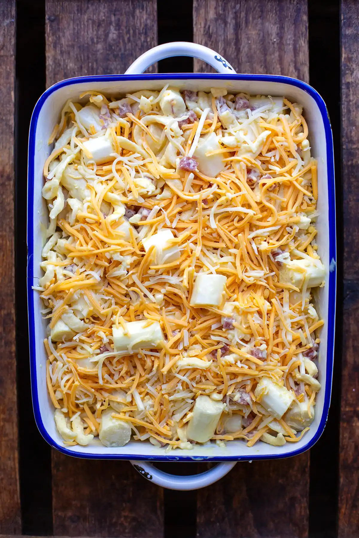Weißer Spargel, Spätzle, Sauce und Schinkenwürfel werden für den schnellen Spargelauflauf in der Auflaufform vermengt