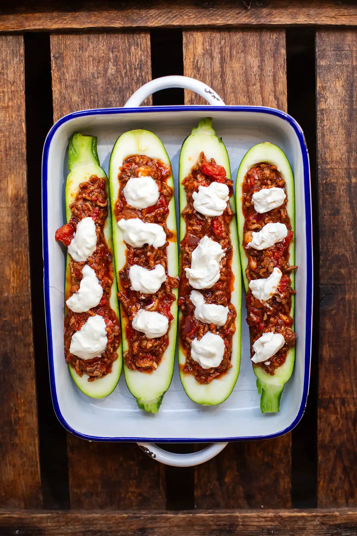 Vorbereitete Zucchini-Schiffchen mit Hackfleisch gefüllt in einer Auflaufform