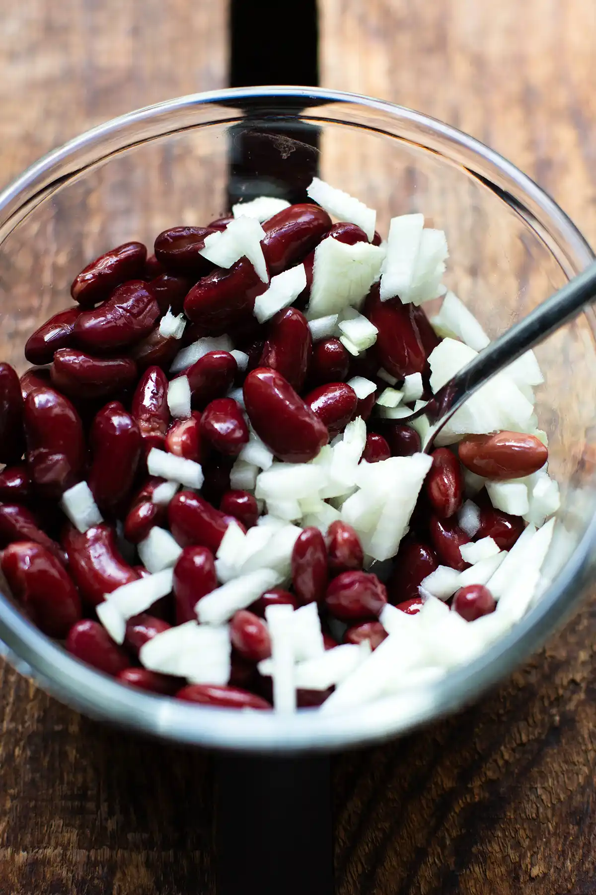 Kidneybohnensalat mit Zwiebeln in einer Salatschüssel auf einem gemütlichen Holzuntergrund
