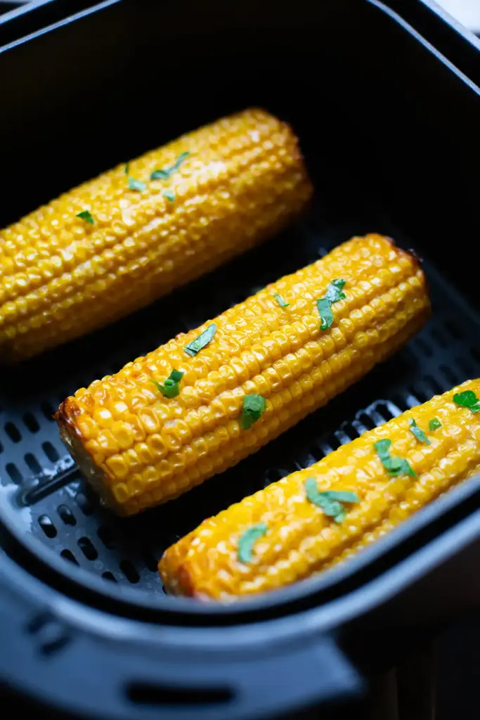 Knusprige Maiskolben fertig zubereitet in der Heißluftfritteuse, perfekt als vegetarischer Snack