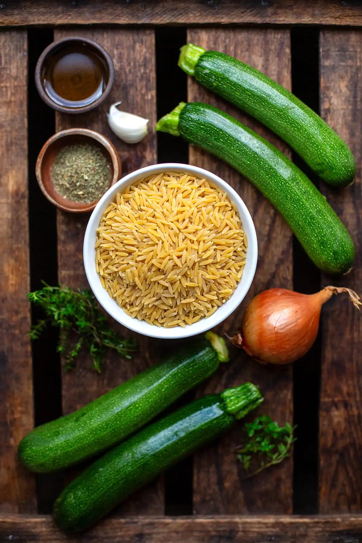 Zutaten für das Zucchini-Nudel-Pfanne: Zucchini, Orzo-Nudeln, Parmesan, Thymian, Öl, Knoblauch und Zwiebeln