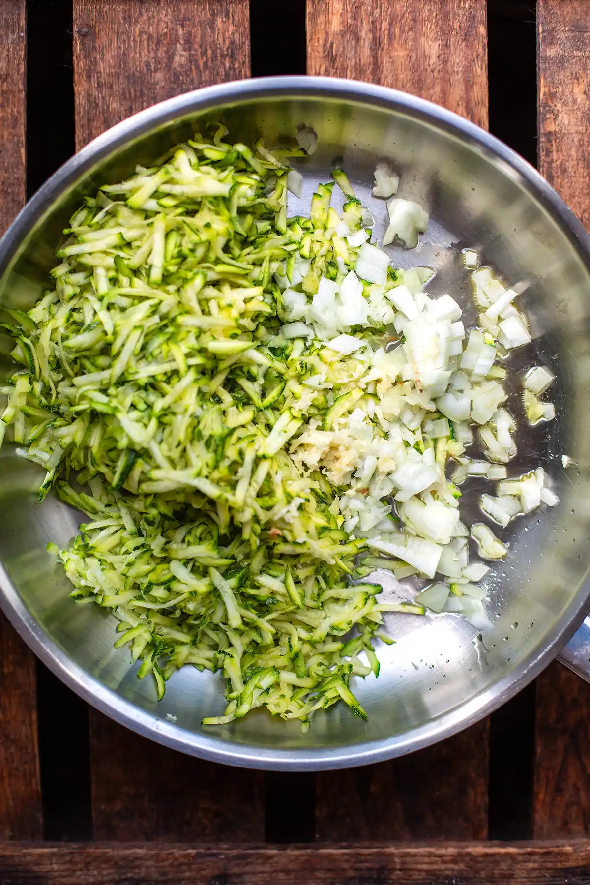 Zucchini, Zwiebeln und Knoblauch werden in der Pfanne angebraten