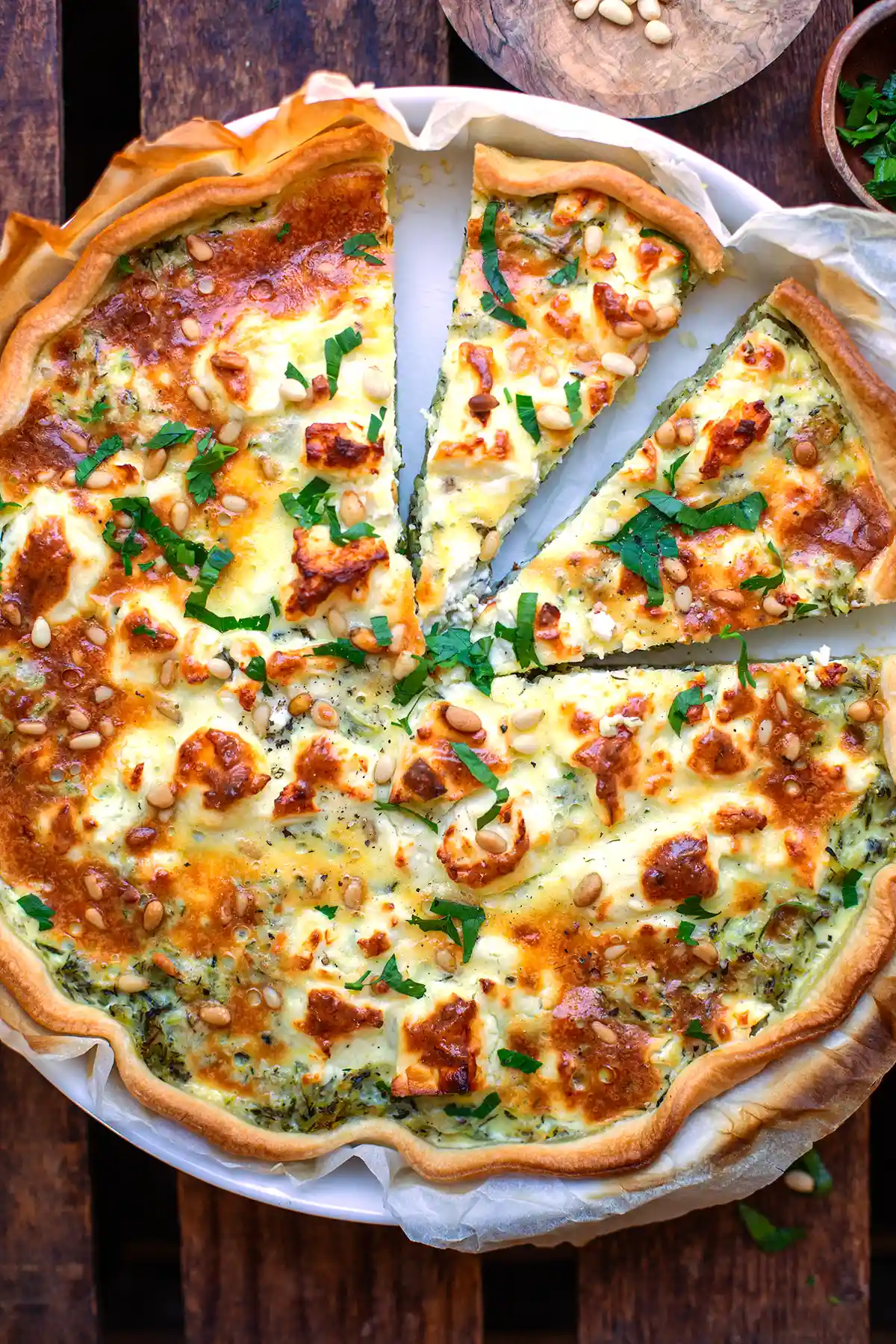 Goldbraun gebackene Zucchini-Quiche mit gerösteten Pinienkernen von oben