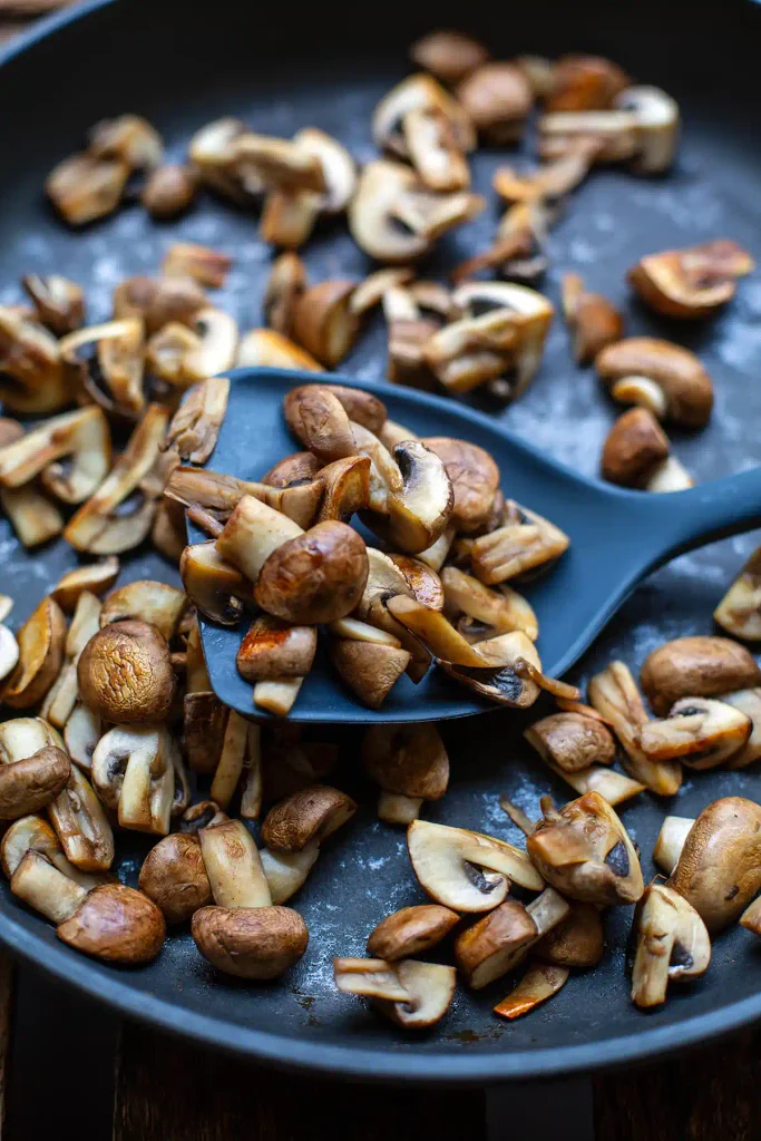 Goldbraun gebratene Champignons in einer trockenen Pfanne ohne Fett