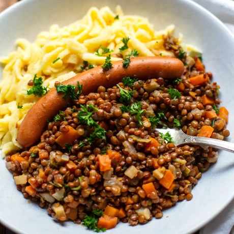 Schwäbische Linsen mit Spätzle und Würstchen im Teller