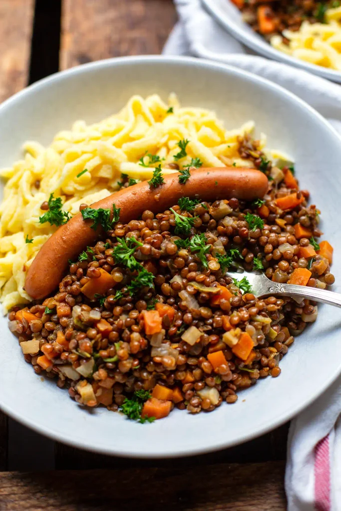 Schwäbische Linsen mit Spätzle und Würstchen im Teller