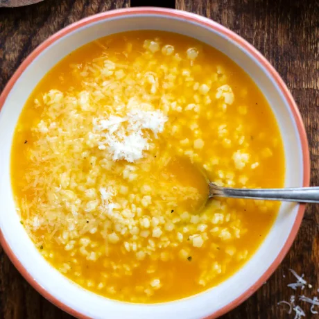 Pastina Suppe mit Sternchennudeln und Parmesan in einer Schüssel.