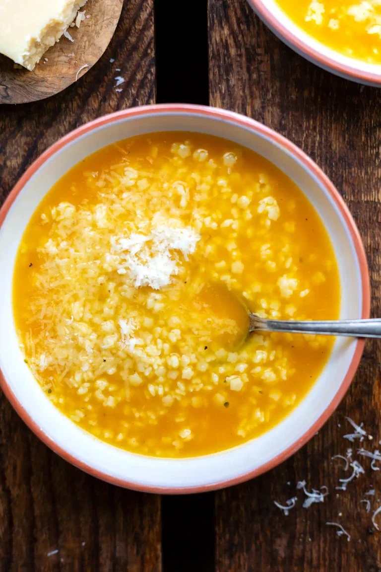 Pastina Suppe mit Sternchennudeln und Parmesan in einer Schüssel.